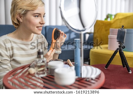 Happy beautiful woman looking at smartphone camera while making vlog stock photo
