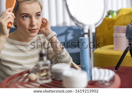 Cropped photo of beautiful woman looking in the mirror and combing stock photo
