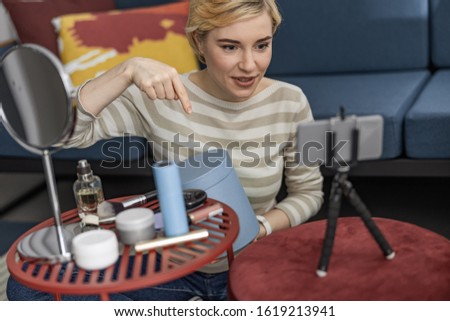 Smiling petty woman making video for her vlog while using box at home stock photo