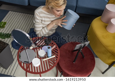 Top view of happy attractive lady making video for her vlog while using box stock photo