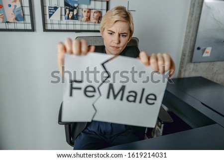 Young woman tearing an inscription on piece of paper stock photo