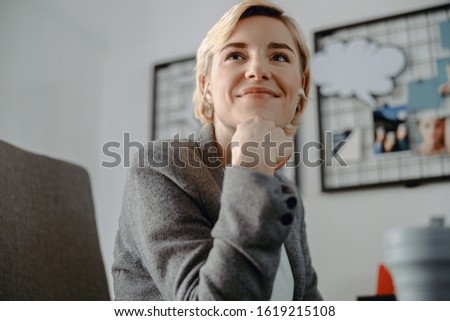 Cropped photo of smiling young lady holding hand on chin stock photo