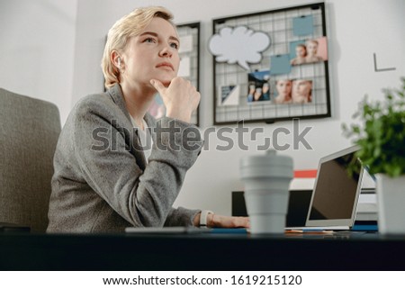 Waist up of attractive lady working with laptop at workplace stock photo
