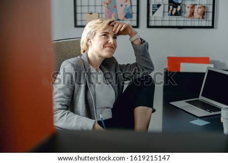 Waist up of happy pretty woman resting at workplace stock photo