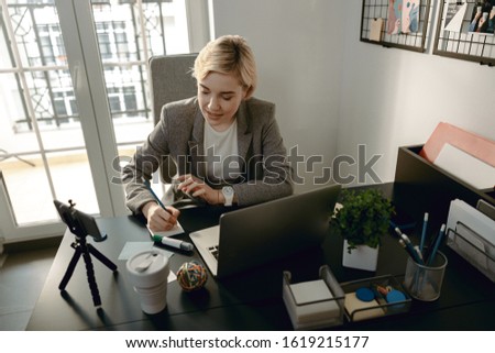 Top view of smiling young lady working at desktop in her office stock photo