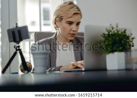 Waist up of attractive lady typing on computer while working in her office stock photo