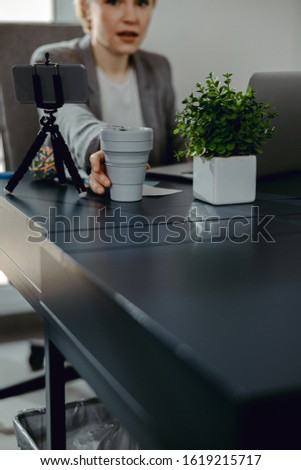 Cropped photo of attractive lady sitting at the table and enjoying hot drink stock photo