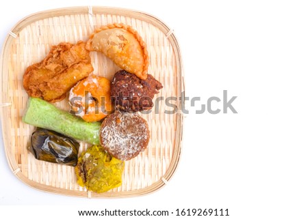 A flatlay picture of famous Nusantara dessert or bitesized snack called "kuih" inside the rattan tray. It is famous streets food in Malaysia and Indonesia.