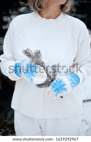 Hands in Knitted Mittens. Winter lifestyle. Wearing Stylish Warm Clothes. Woman in warm clothes. Fashion outdoor