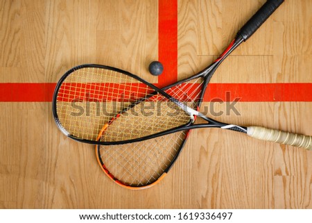 Squash rackets and ball on court floor, top view Royalty-Free Stock Photo #1619336497
