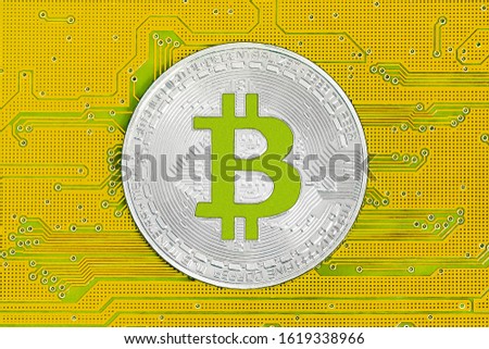 Bitcoin on yellow circuit board. Bitcoin cryptocurrency on computer electronic circuit board. Cybercrime background.