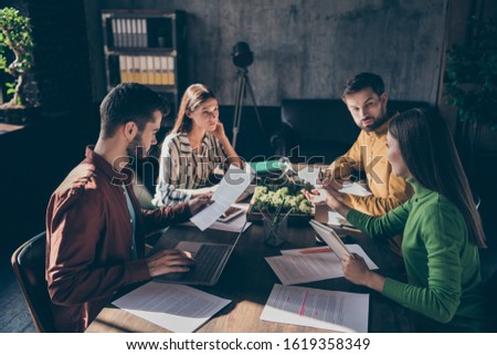 Serious experienced businesspeople wearing casual formal-wear discussing preparing law case contract tender assignment agreement at modern industrial loft brick style interior work place station Royalty-Free Stock Photo #1619358349
