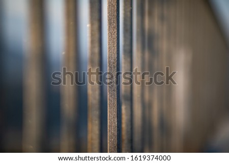 Close up view of a metal fence bars with blurred space and natural light