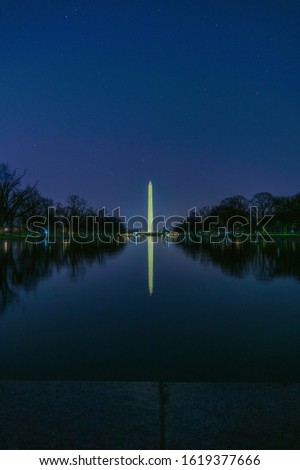 Washington Monument across the Reflecting Pond at night with some stars