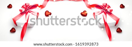 Valentine day composition: white gift box with bow and red ribbon heart, photo template, background. Top View with copy space, romance seasonal holiday
