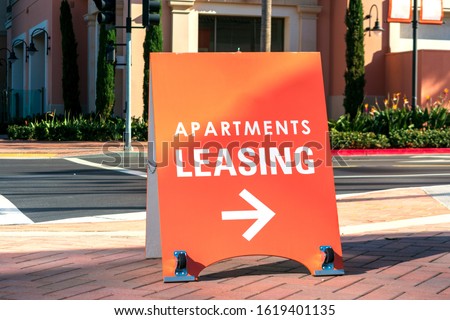 Apartments leasing sign promotes the rental property on the street and shows direction where the rental office is located.