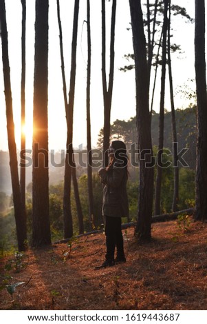 Young Asian girl shooting landscapes photos in the sunset time, traveling concept