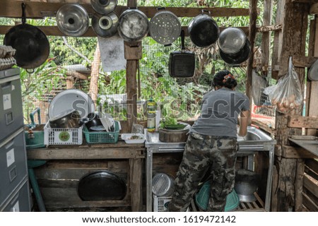 Picture of a woman in a thai kitchen with her back to the camera