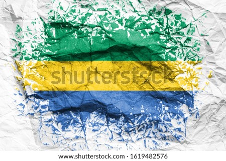 The national flag of the Gabon is painted on crumpled paper. Flag printed on the sheet. Flag image for design on flyers, advertising.
