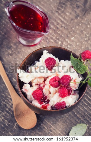 Fresh dairy products - cottage cheese with raspberry on wooden background.  Rustic style. Bio/organic/natural ingredients. Healthy eating.