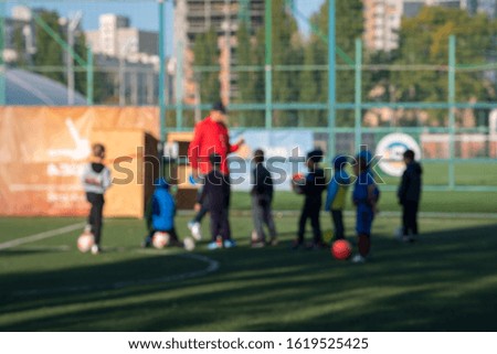 Boys at a football training. The concept of a healthy lifestyle and sport. Blurry