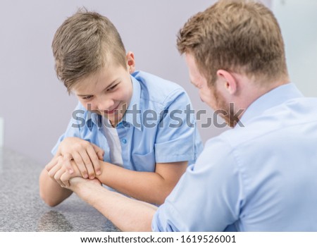 Young boy wins his father in arm wrestling