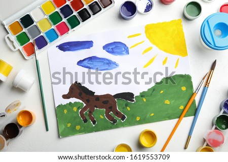 Flat lay composition with child's painting of horse on white table