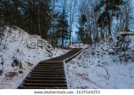 Wooden stairs leading to the snowy Hill of the Three Crosses in Vilnius at dawn. Lithuania