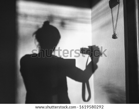 shadow of a girl with a camera on the wall in the room