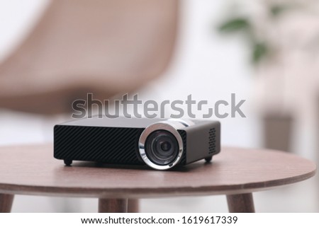 Modern video projector on wooden table indoors