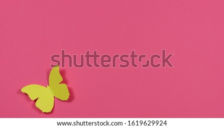 Colored butterflies fly around on a colored paper background. Royalty-Free Stock Photo #1619629924