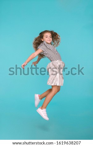 Cute girl jumping, in studio