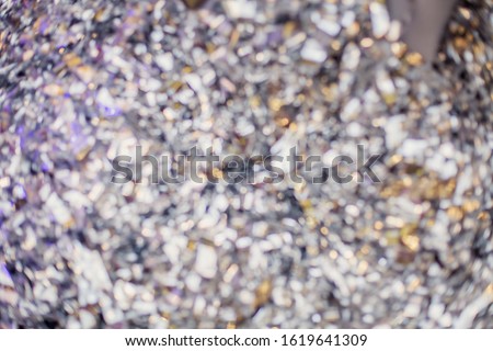 foil confetti blurred silver multicolored bokeh background. Holiday focus without focus
