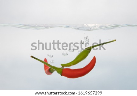 
Picture of green peppers and red peppers in the water, white background