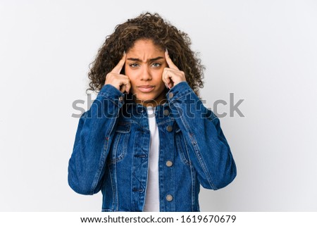 Young african american woman focused on a task, keeping forefingers pointing head.