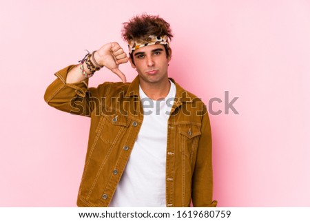 Young hipster man isolated Young man going to a festival showing a dislike gesture, thumbs down. Disagreement concept.