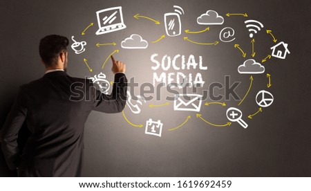 businessman drawing social media icons with SOCIAL MEDIA inscription, new media concept