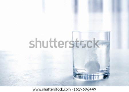 Glass of water with effervescent tablet on light table indoors, space for text