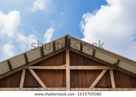 Gable of wooden houses and galvanized sheet walls with blue sky is background and copy space for your Text or logo