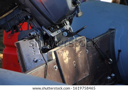 Increasing the transom height with handmade mechanical lift, adjusting the position of inflatable PVC boat outboard motor clamp Royalty-Free Stock Photo #1619758465