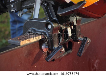 Fast raising the transom height with wooden plank, adjusting the position of boat outboard motor clamp Royalty-Free Stock Photo #1619758474
