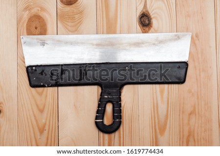 Metal spatula on a wooden background. Stock photo flat style.