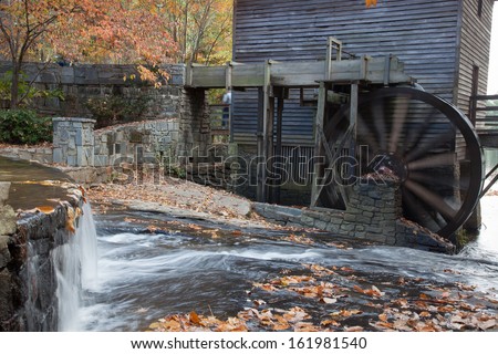 Old grist mill, with a water driven wheel to grind and a creek beside, flowing over stones