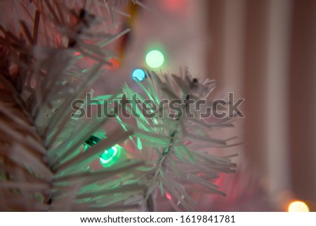 Macro shot of a white artificial Christmas tree with lights