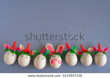 top view flat lay frame of easter eggs unicorns and rabbit on a gray background with  place for text
