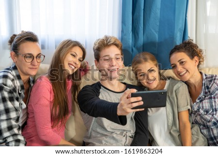 Group of young people making a selfie sitting on a sofa. Lifestyle