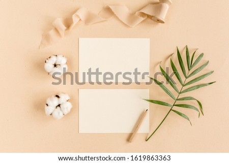 Mockup invitation, blank greeting card and tropical palm leaves. Flat lay, top view.
