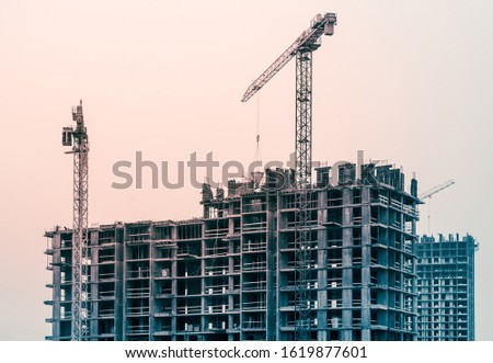 Construction crane and building construction site tinted in blue and red colors