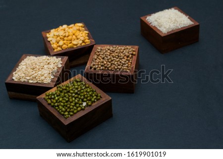 Grains stocked in wooden box on black background - Grains and pulses