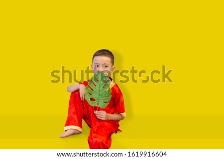 Happy Asian child portrait on yellow backdrop, Chinese new year concept.